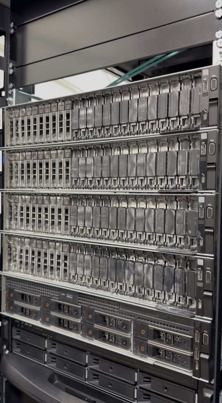 Frontali server e bay disco con accumulo di polvere da cantiere prima della pulizia tecnica